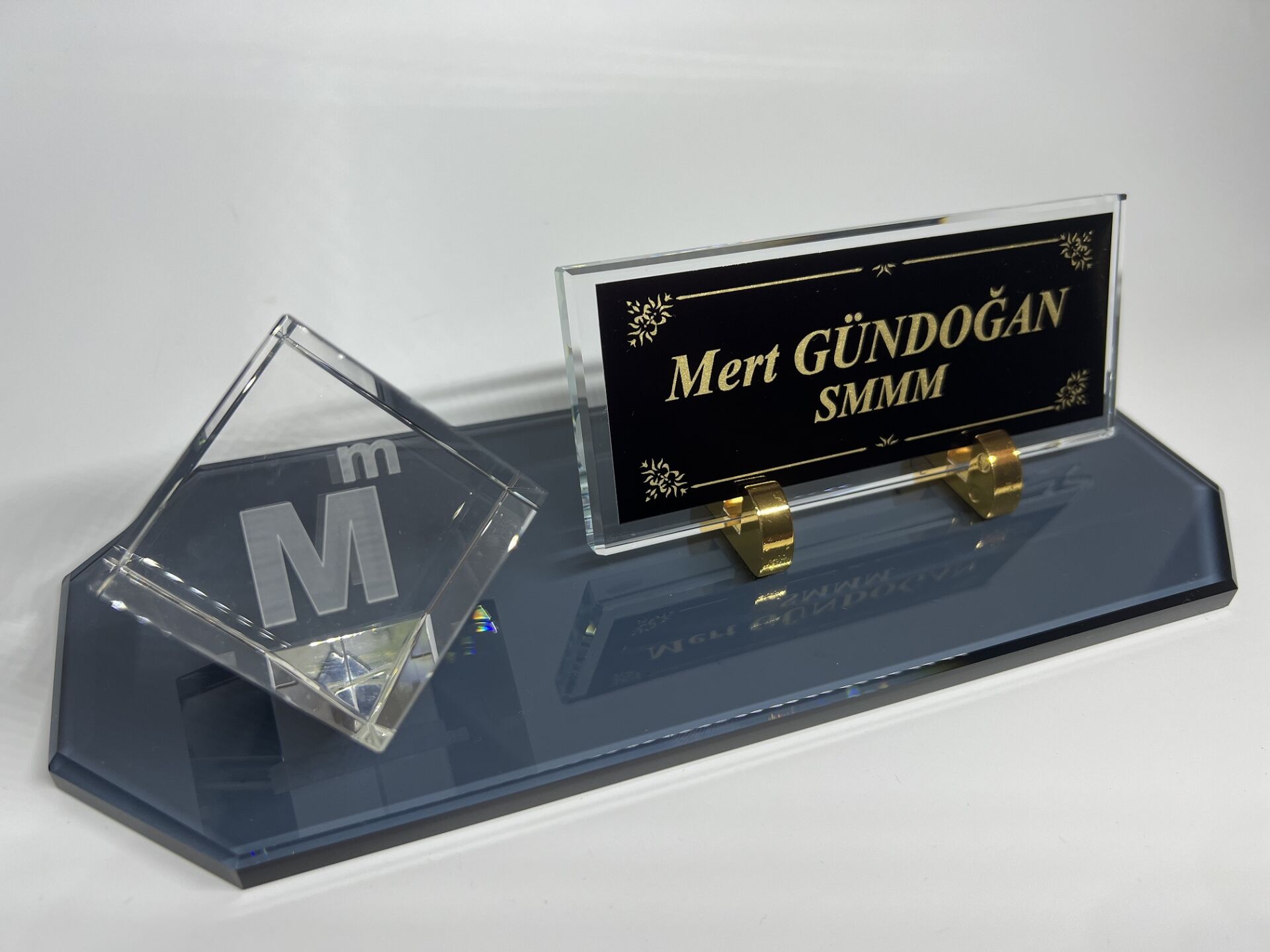 Füme Cam Masa İsimlik ve Cam İçi Mali Müşavirlik Logolu Küp Patlatma Siyah Zemin Altın Yazılı